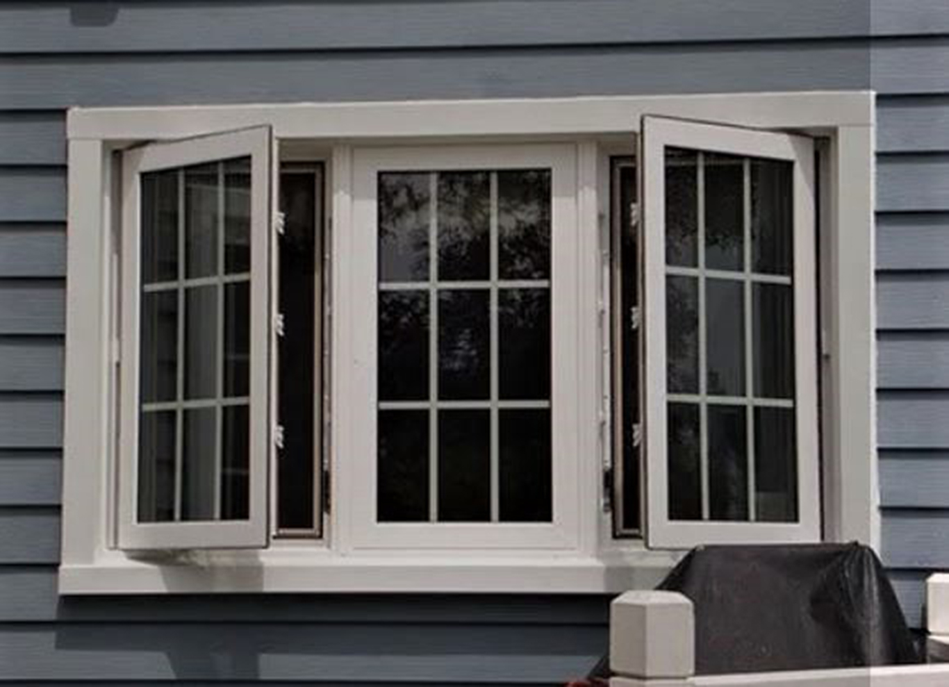 Black tinted glass with white casement windows.