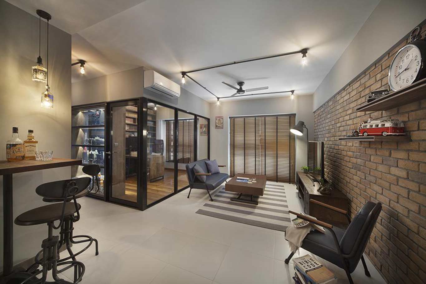 Walls of bedroom taken down and replaced with black-framed glass panels to achieve an open-concept layout