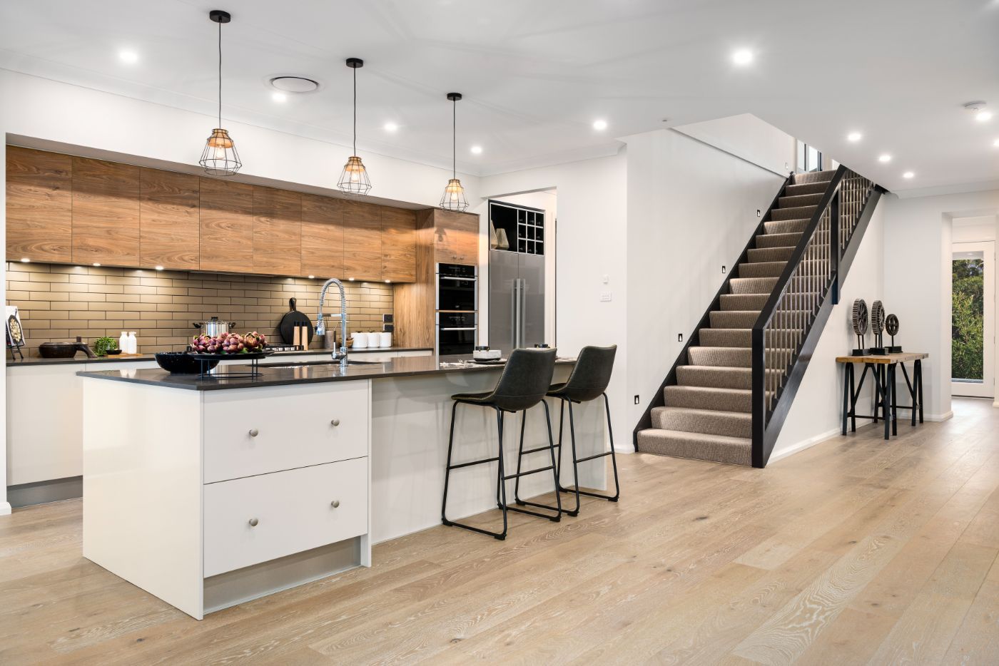  Kitchen island in dark slate marble countertop and white base finish stands out against a kitchen of light-colored cabinetry