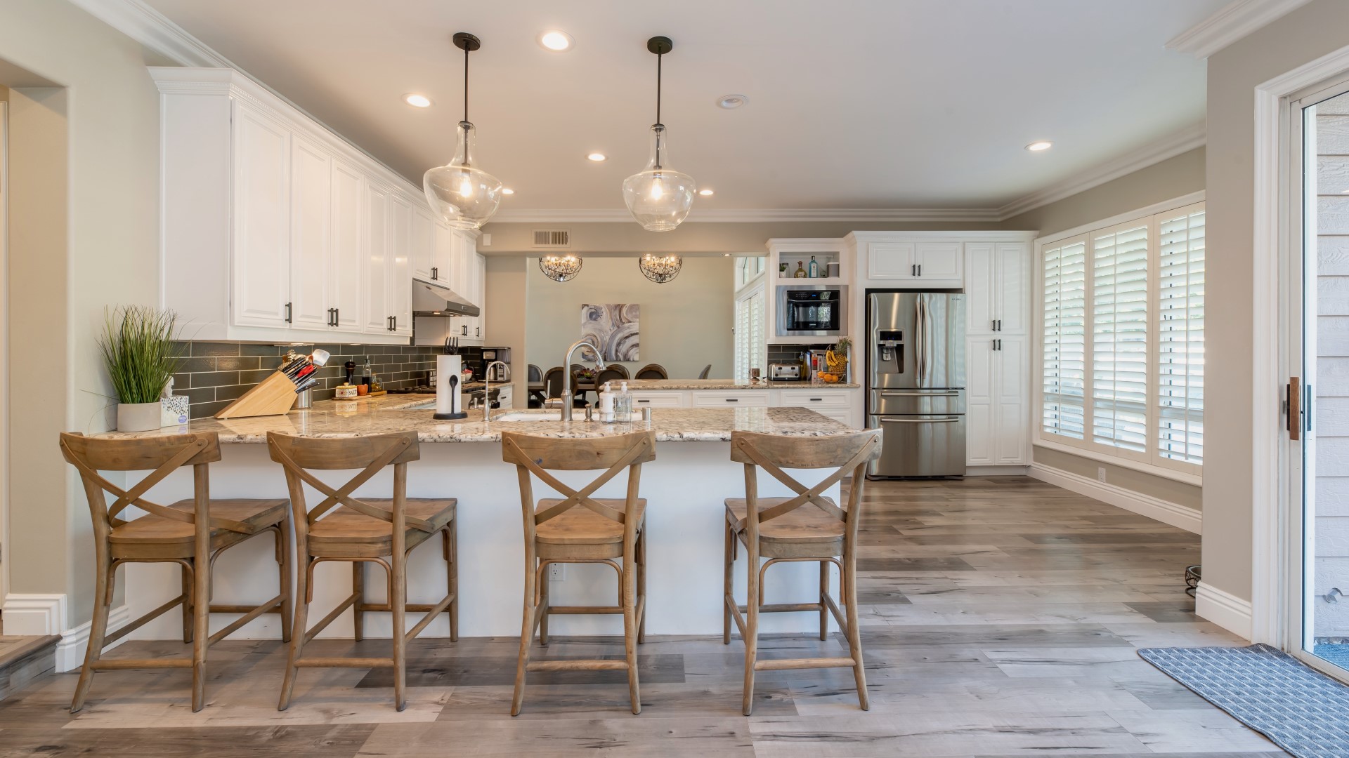 Open concept kitchen with wooden chairs lining bar countertop partition