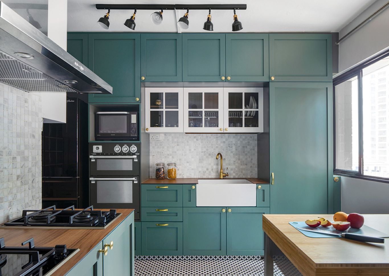 Kitchen cabinets in dark teal paired with geometric patterned flooring and wooden countertops