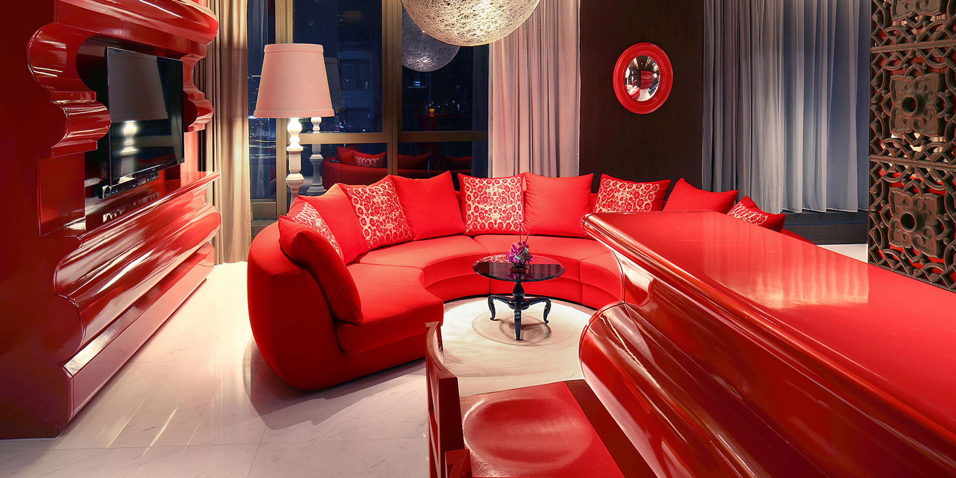 Red sofa with red cushions, red bar top with red high chairs, and red TV console in an Oriental Chinese living room