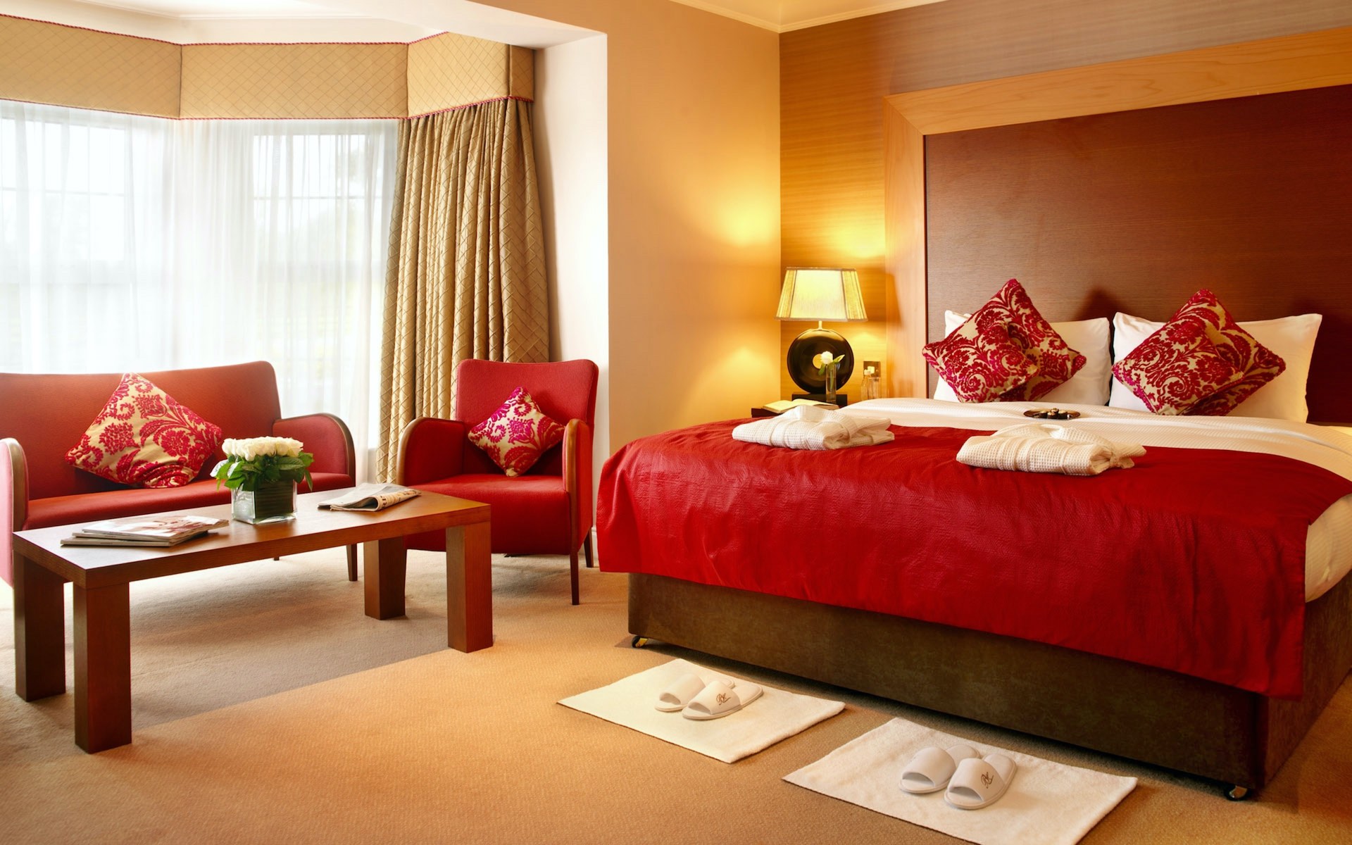 Red textiles for sofa and bed cover with red and gold cushions in a modern bedroom