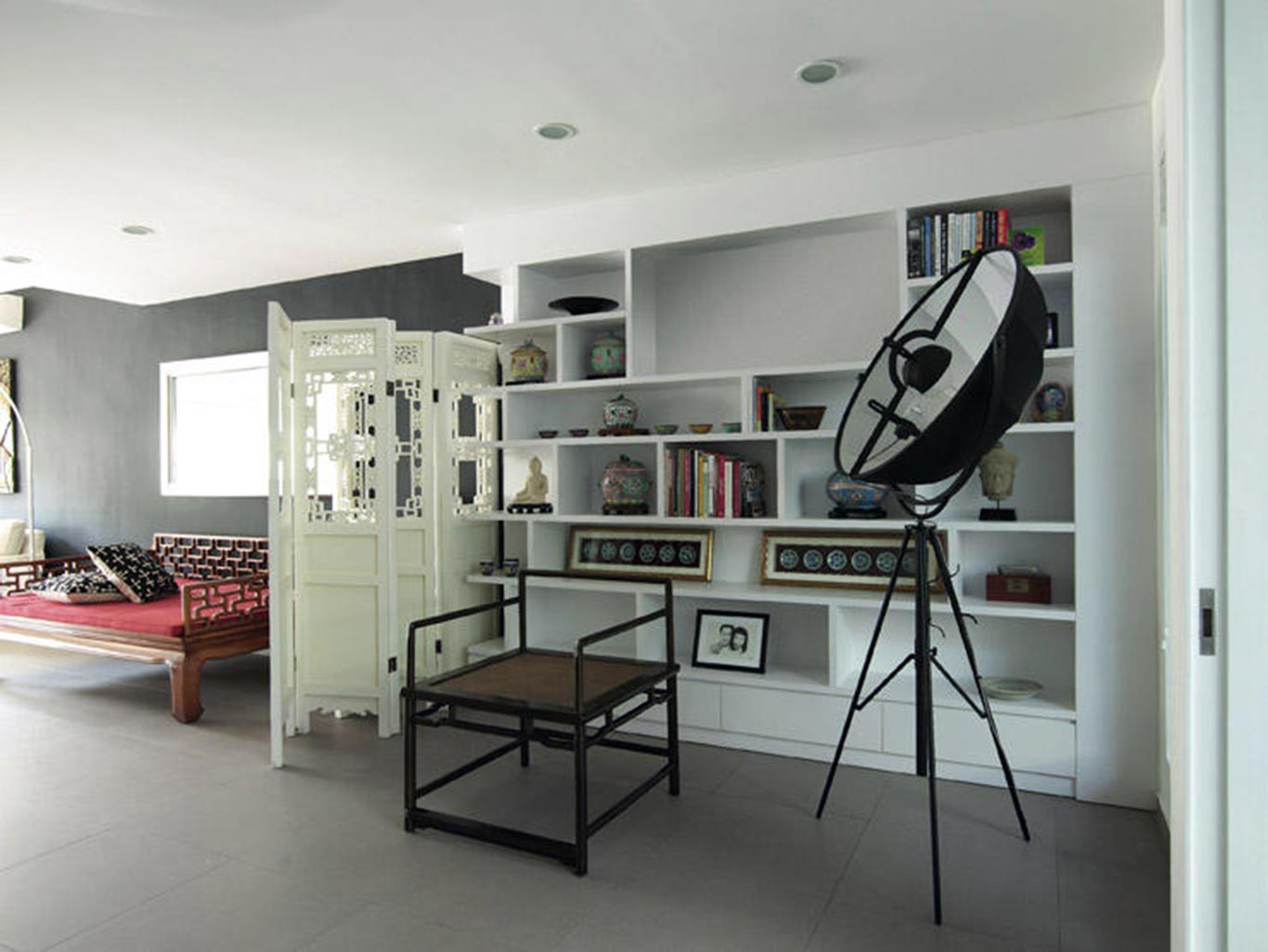 Large black dining table with gray chairs against a large image of birds and plants on the wall