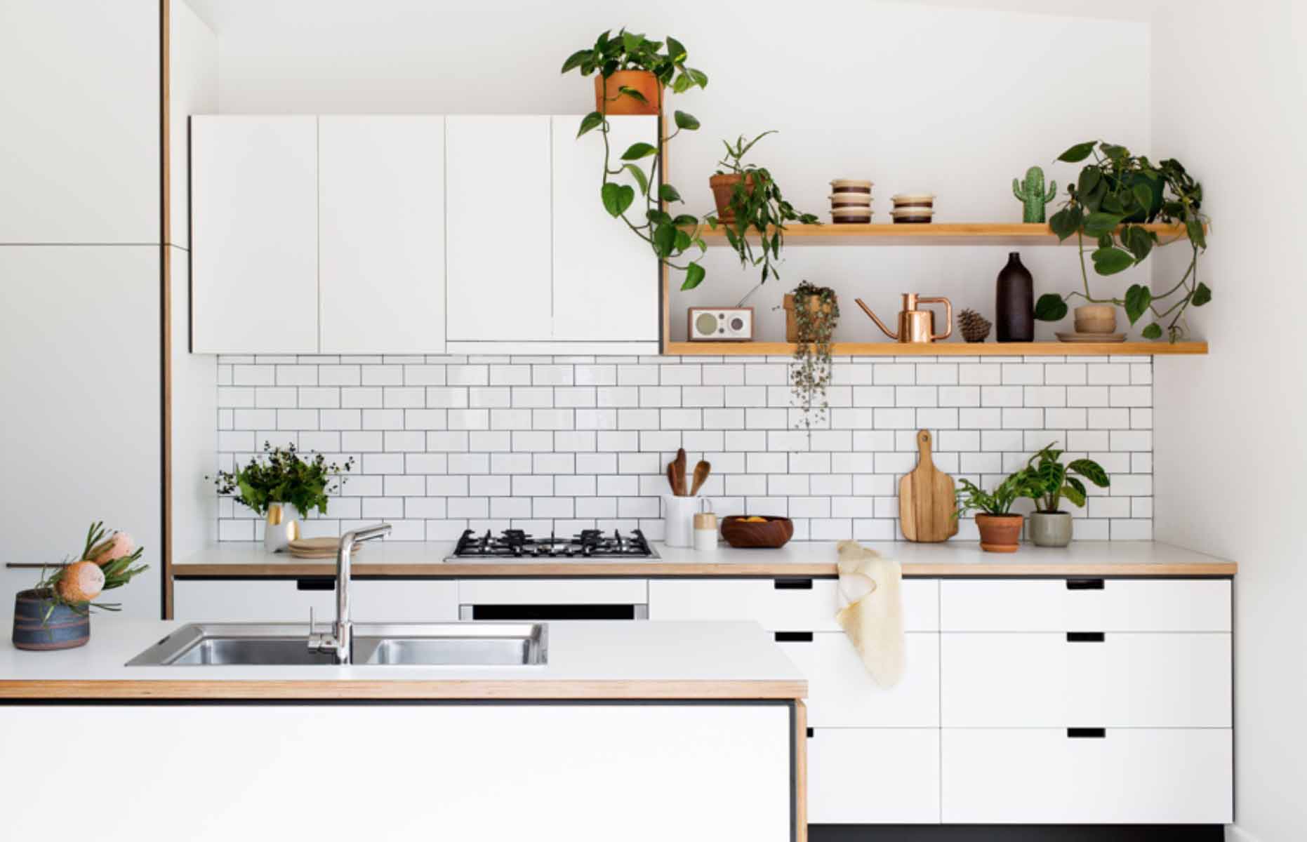 White gloss backsplash and wooden fixtures in a modern Scandinavian HDB kitchen