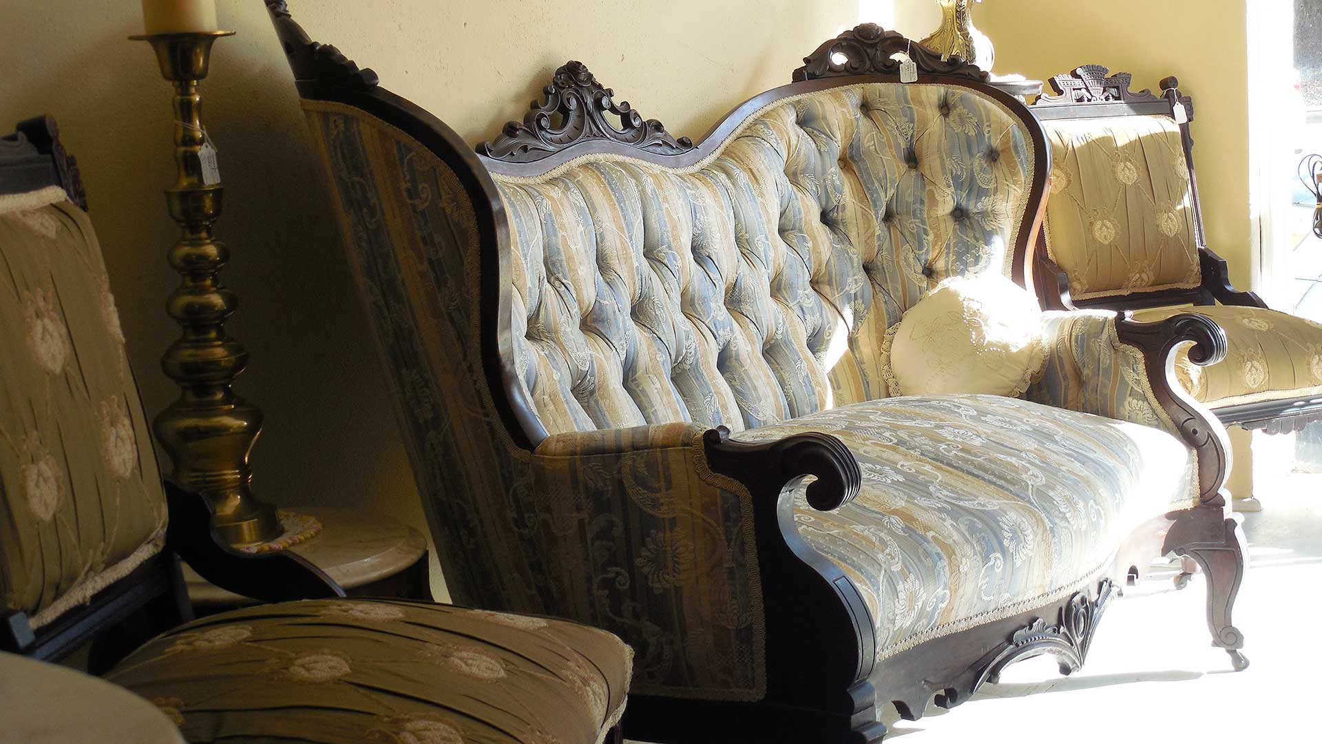 Ornately-carved wooden 2-seater sofa characteristic of the Victorian era.