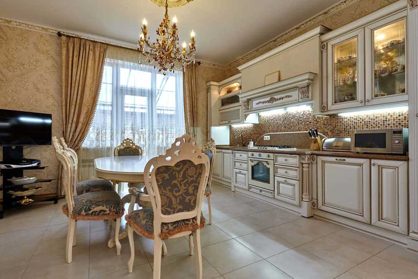 Victorian style kitchen and enclosed dining table of four ornately-carved chairs with damask upholstery.