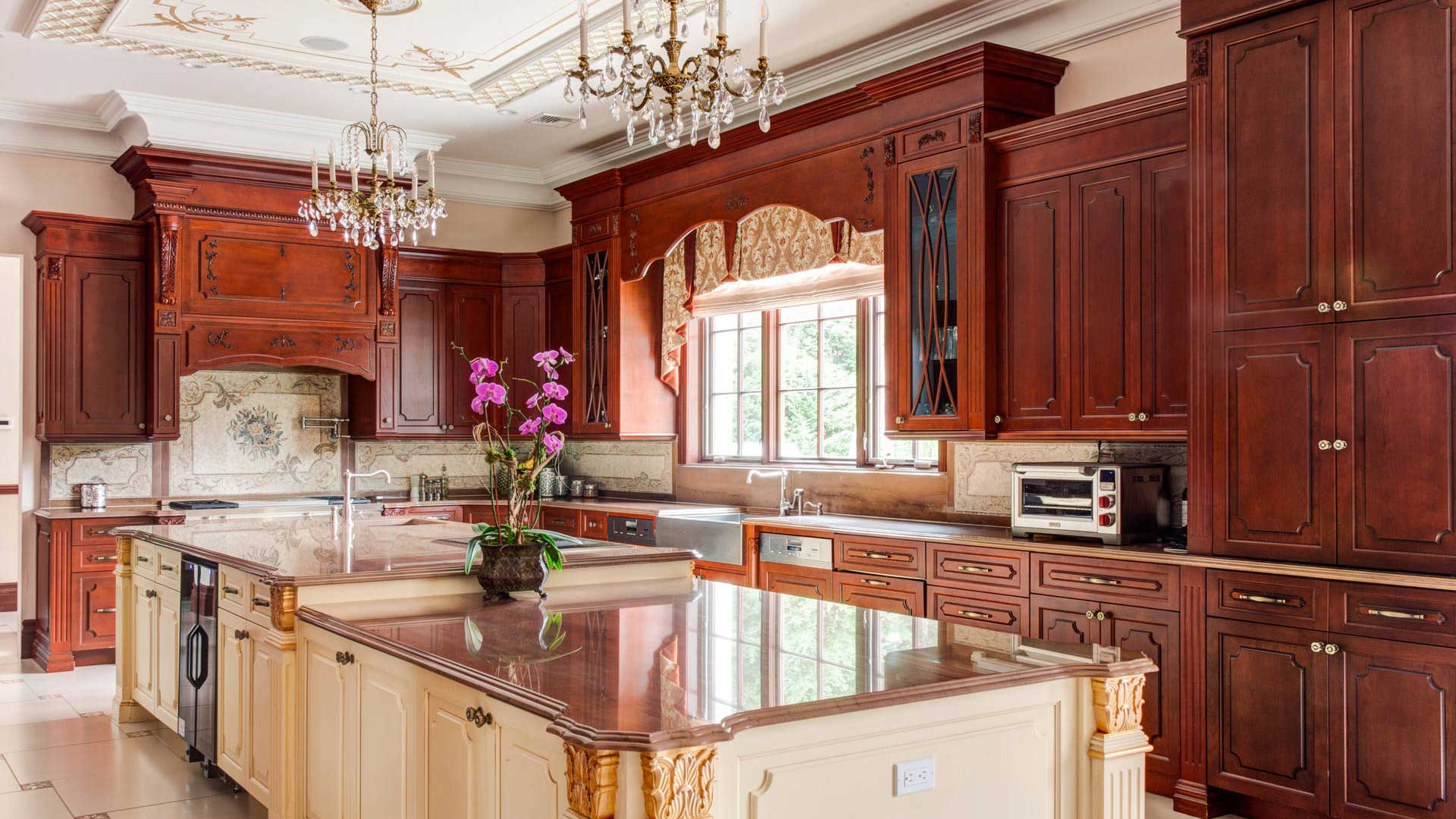 Open concept Victorian design kitchen with ornately-carved wooden center island.