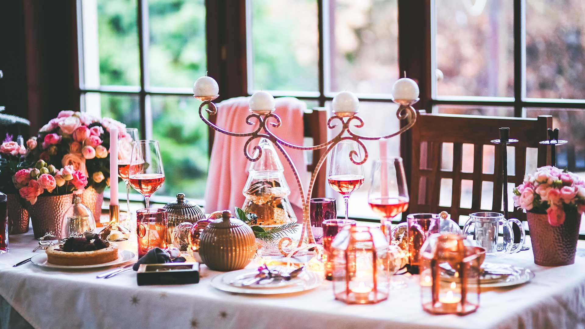 Table setting with wine glasses, mini lanterns and flower pots.